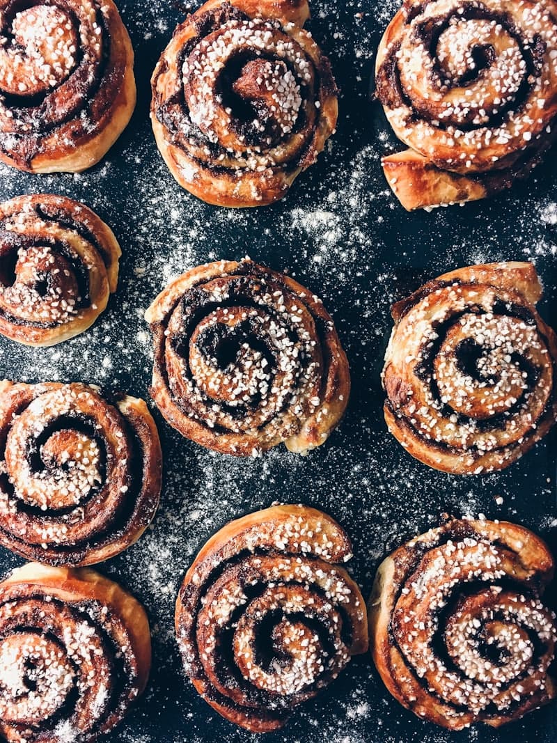 Nygräddade kanelbullar med pärlsocker på ett galler